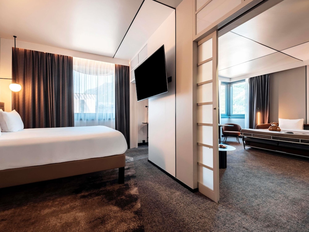Suite con una cama doble y un sofá cama doble del hotel Novotel Grenoble Centre