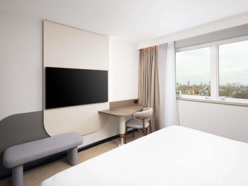 Habitación Deluxe Priviledge con cama extragrande, ducha de efecto lluvia y vistas a la ciudad del hotel Mercure London Earls Court. Foto 8