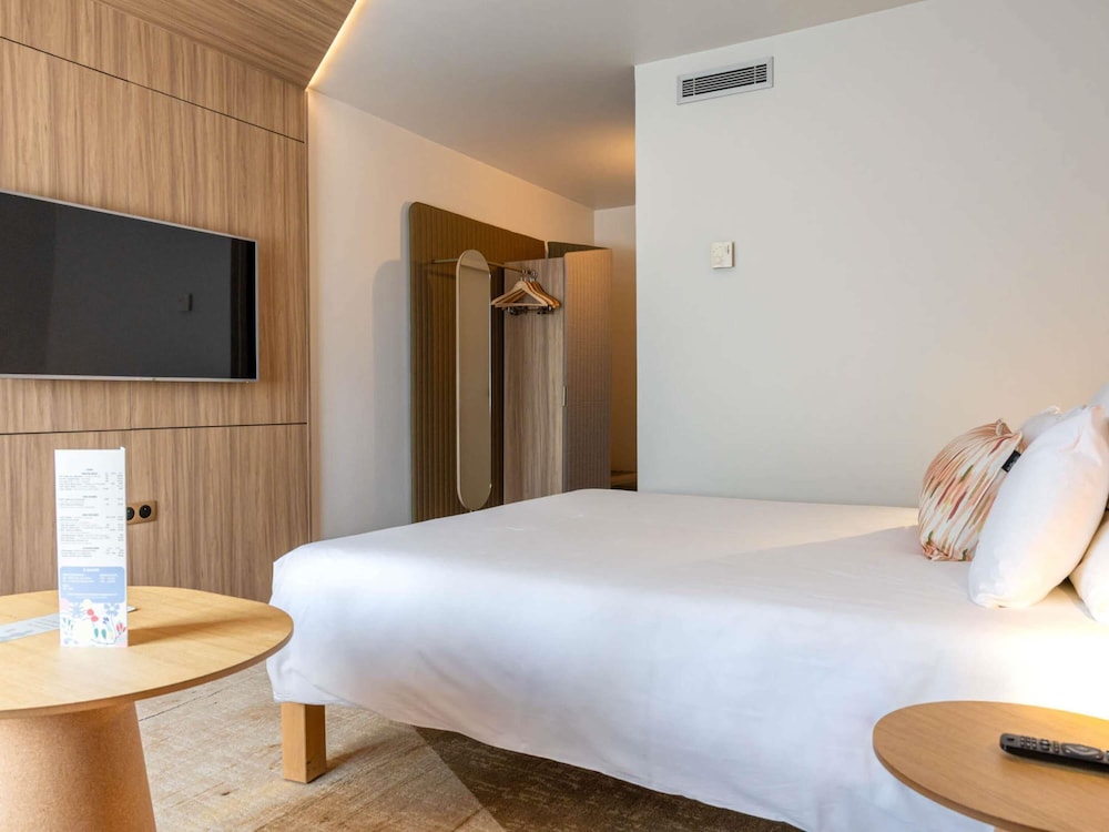 Habitación Superior reformada con una cama doble y un sofá cama doble del hotel Novotel Toulouse Purpan Aéroport. Foto 1
