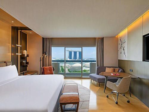 Habitación Premier Prestige con balcón y vistas a la bahía Marina - Cama extragrande del hotel Swissotel The Stamford, Singapore. Foto 2