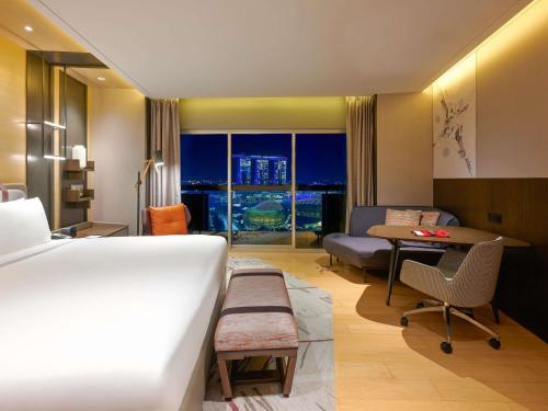 Habitación Premier Prestige con balcón y vistas a la bahía Marina - Cama extragrande del hotel Swissotel The Stamford, Singapore. Foto 3