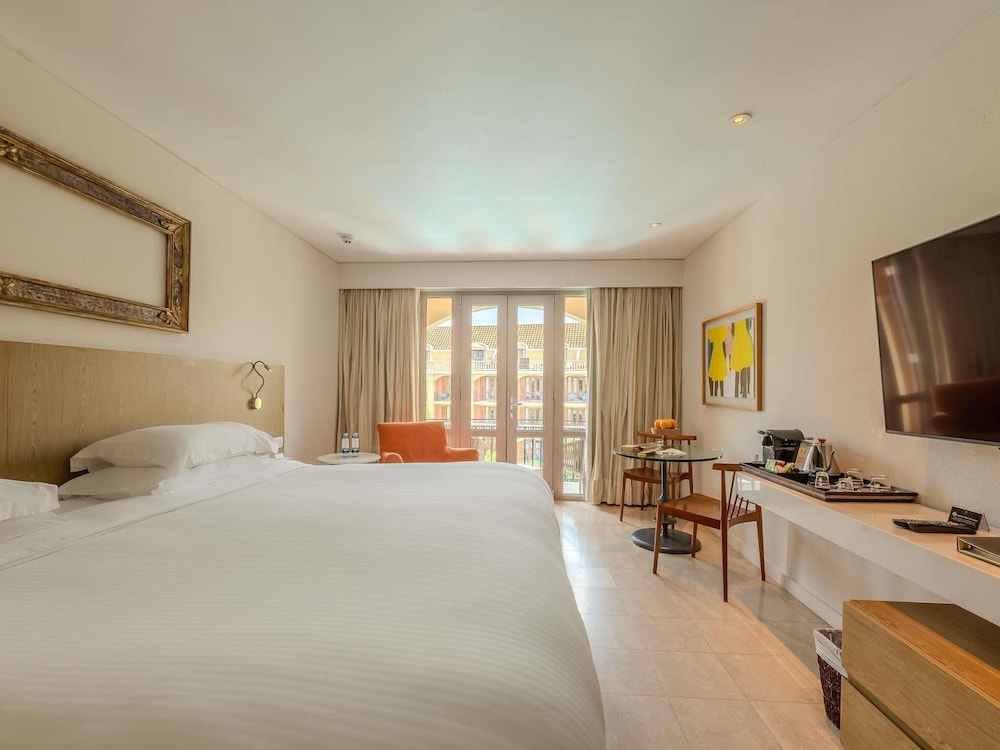 Habitación Superior con 1 cama king size, balcón y vistas a la piscina del hotel Sofitel Legend Santa Clara Cartagena