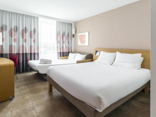 Habitación Deluxe con cama grande y sofá del hotel Novotel Edinburgh Park. Foto 1