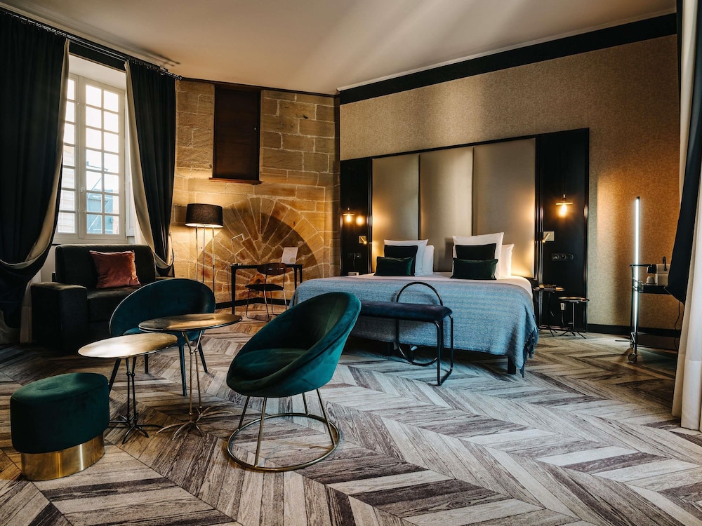 Habitación Privilege con una cama doble y un sillón del hotel Mercure Figeac Viguier du Roy. Foto 5