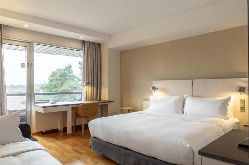 Habitación con balcón - Cama extragrande del hotel Hilton Helsinki Kalastajatorppa. Foto 1