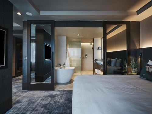 Suite Executive Deluxe con cama extragrande, acceso al salón y vistas - Planta superior del hotel Pullman East Melbourne