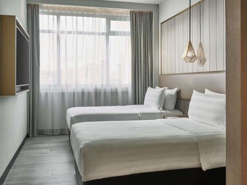 Family Quadruple Room, 1 King Bed and 2 Single Beds del hotel Novotel Singapore on Kitchener. Foto 1