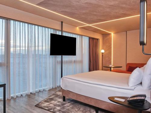 Suite Deluxe con 1 cama doble, sofá y terraza del hotel Novotel Istanbul Bomonti
