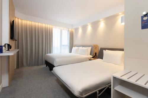 Habitación estándar con cama grande y sofá cama individual - Desayuno gratuito del hotel Holiday Inn Express Brussels - Airport, an IHG Hotel. Foto 1