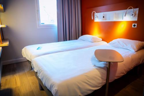 Habitación con 2 camas individuales del hotel ibis budget Reims Parc Des Expositions. Foto 4