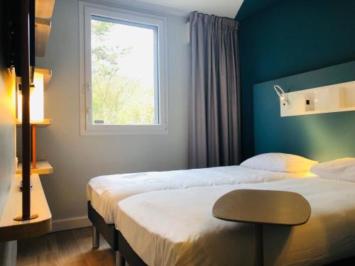 Habitación con 2 camas individuales del hotel ibis budget Reims Parc Des Expositions. Foto 10