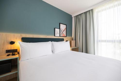 Habitación con cama extragrande y sofá cama del hotel Spark By Hilton Madrid Alcala. Foto 3
