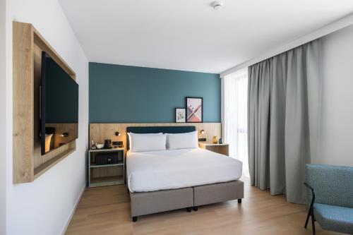 Habitación con cama extragrande y sofá cama del hotel Spark By Hilton Madrid Alcala. Foto 6