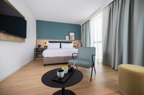 Habitación con cama extragrande y sofá cama del hotel Spark By Hilton Madrid Alcala. Foto 2