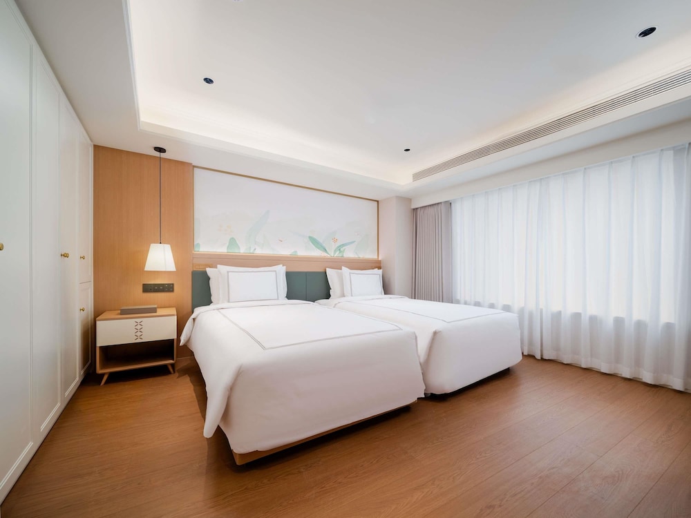 Habitación Swiss Executive con sala de estar, dormitorio y dos camas individuales del hotel Swissôtel Living Shanghai Hongqiao. Foto 5