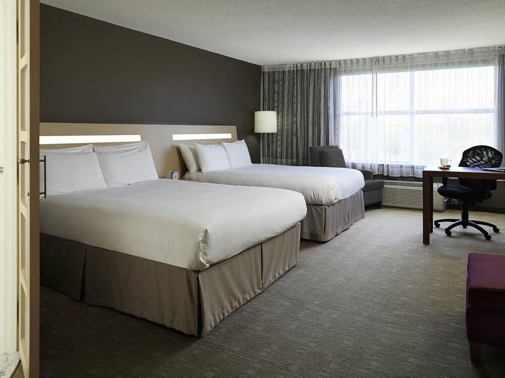 Habitación ejecutiva con 2 camas queen size y 1 sofá cama del hotel Novotel Montreal Aeroport