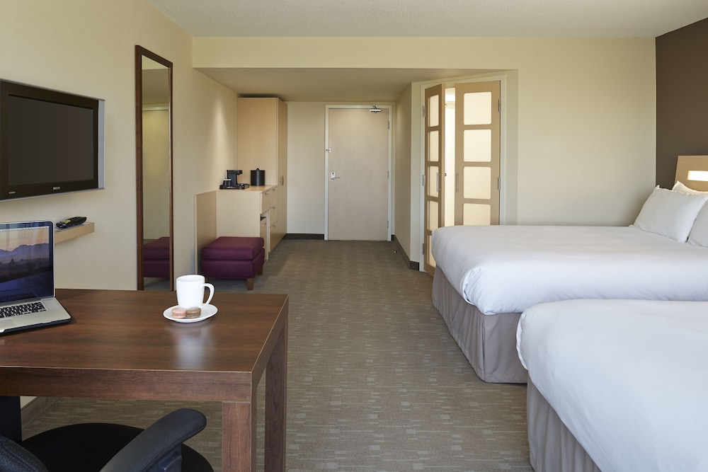 Habitación ejecutiva con 2 camas queen size y 1 sofá cama del hotel Novotel Montreal Aeroport. Foto 1