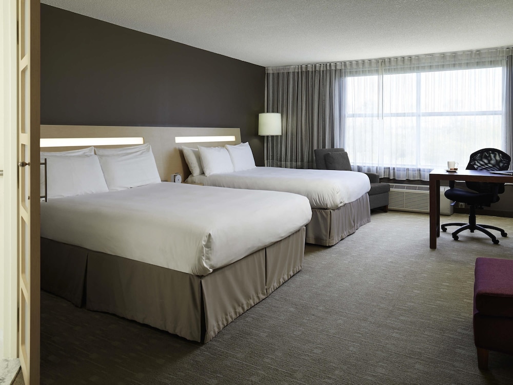 Habitación ejecutiva con 2 camas queen size y 1 sofá cama del hotel Novotel Montreal Aeroport. Foto 5