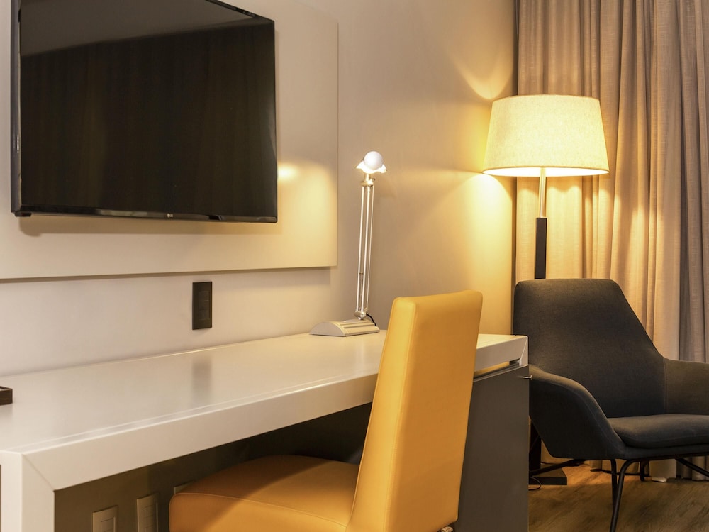 Habitación de categoría superior con una cama king size y vistas parciales al mar del hotel Novotel Florianópolis. Foto 1
