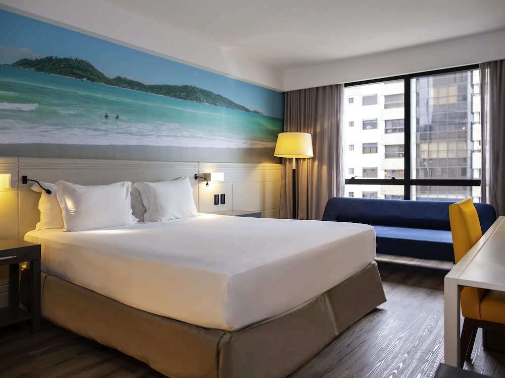 Habitación Superior con 1 cama king size, 1 sofá cama y vistas parciales al mar del hotel Novotel Florianópolis