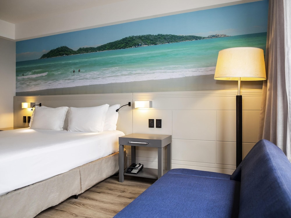 Habitación Superior con 1 cama king size, 1 sofá cama y vistas parciales al mar del hotel Novotel Florianópolis. Foto 3