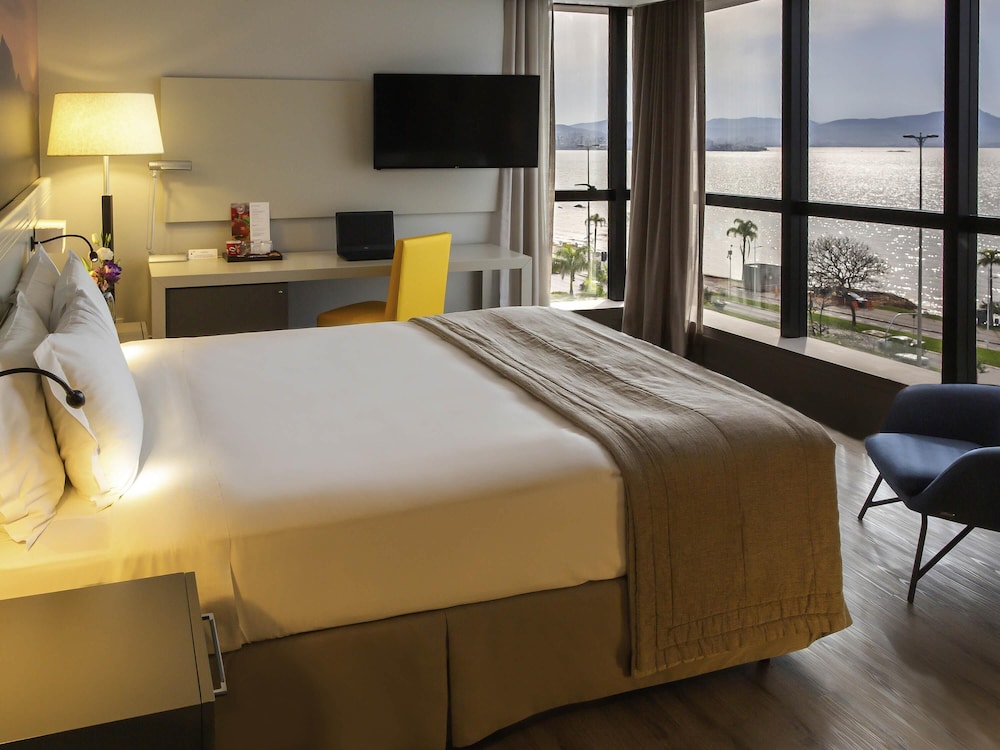 Habitación Luxury con una cama king size y vistas frontales al canal del hotel Novotel Florianópolis