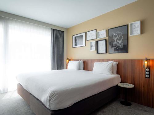 Habitación Superior con cama grande y sofá del hotel Mercure Paris Montparnasse Pasteur. Foto 5