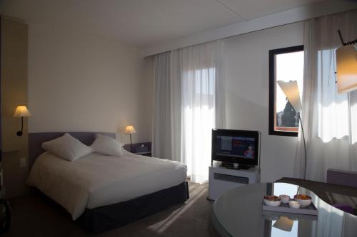 Habitación Deluxe con cama grande y sofá cama del hotel Novotel Marrakech Hivernage. Foto 6