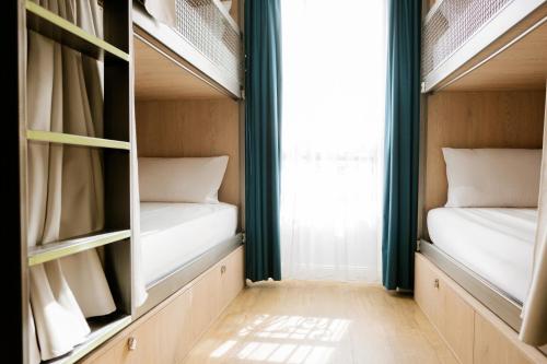 Cama en habitación femenina compartida de 4 camas del hotel The Playce and Bar By Happyculture. Foto 4