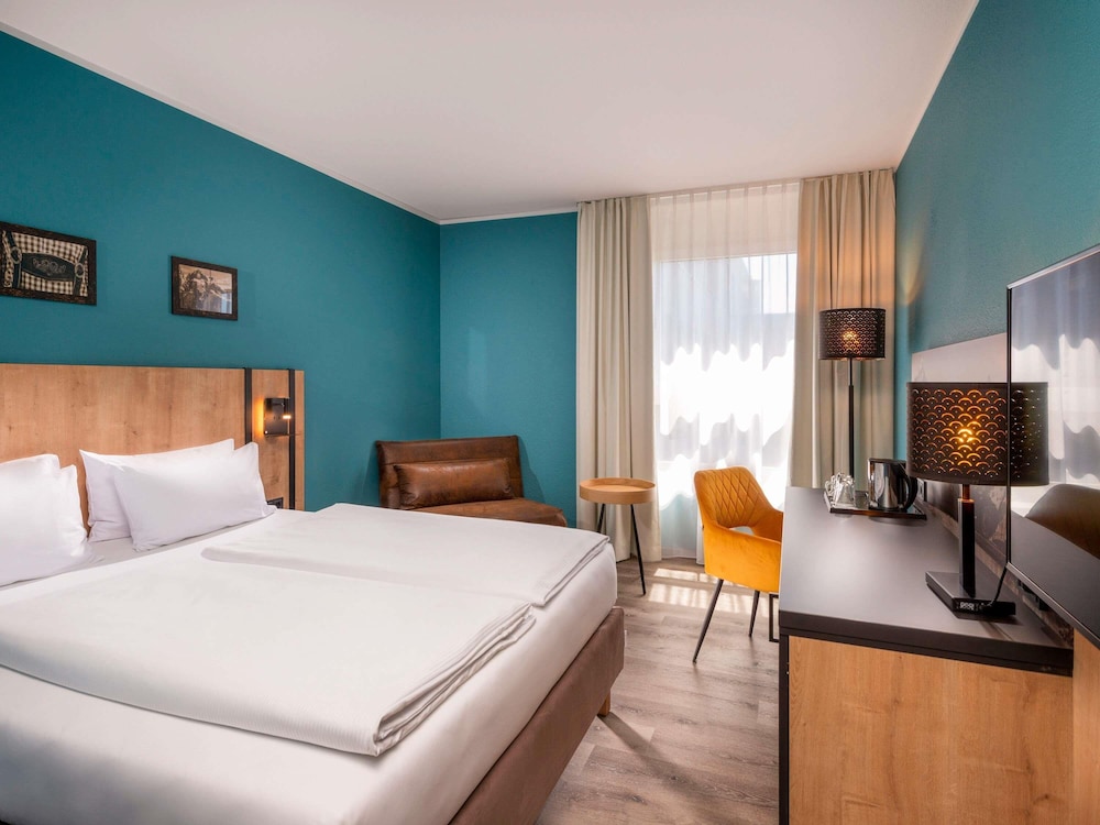 Habitación de negocios con 1 cama queen size lado patio del hotel Mercure Munich Neuperlach Sur. Foto 2