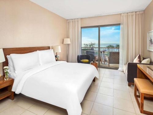 Habitación Doble Superior con cama grande y vistas a la piscina del hotel Mövenpick Resort and Spa Tala Bay Aqaba. Foto 3
