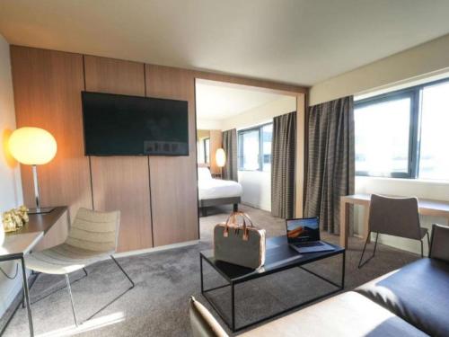 Suite Junior, cama tamaño king, sala del hotel Pullman Bordeaux Lac