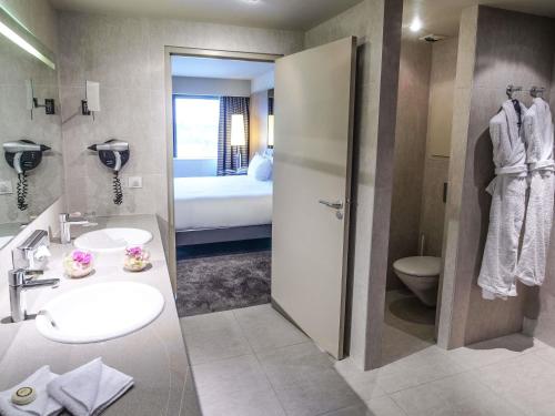 Suite Junior, cama tamaño king, sala del hotel Pullman Bordeaux Lac. Foto 7