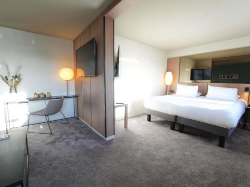Suite Junior, cama tamaño king, sala del hotel Pullman Bordeaux Lac. Foto 8