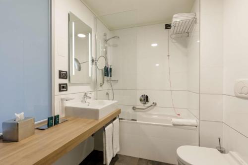 Suite con 1 cama extragrande y zona de estar del hotel Doubletree By Hilton Milan. Foto 2