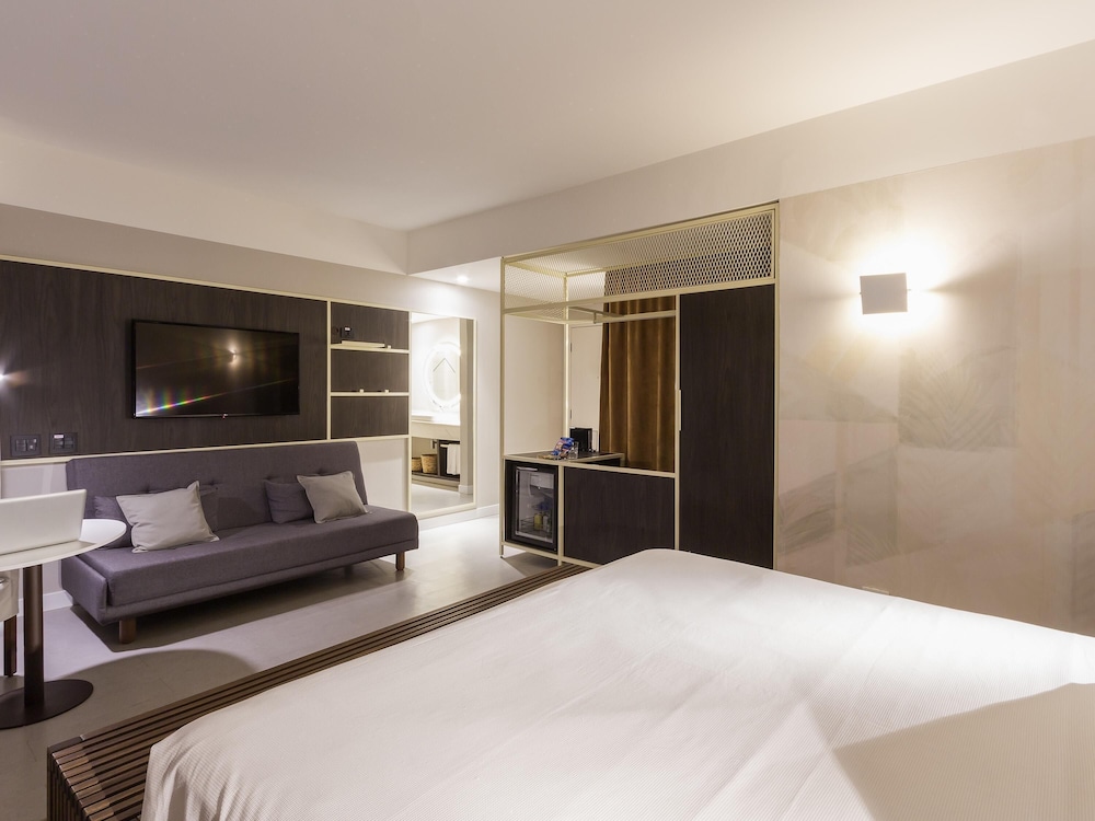Suite Luxury familiar con una cama king size y un sofá cama del hotel Novotel Salvador Rio Vermelho