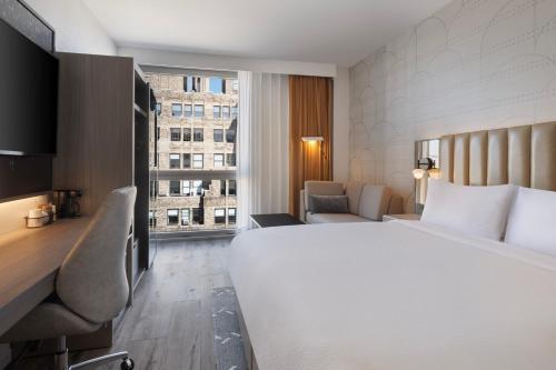 Habitación con cama extragrande y sofá cama del hotel Courtyard New York Manhattan Soho