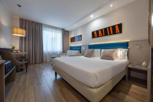 Habitación Doble Estándar con sofá cama del hotel Ih Hotels Milano Lorenteggio. Foto 1