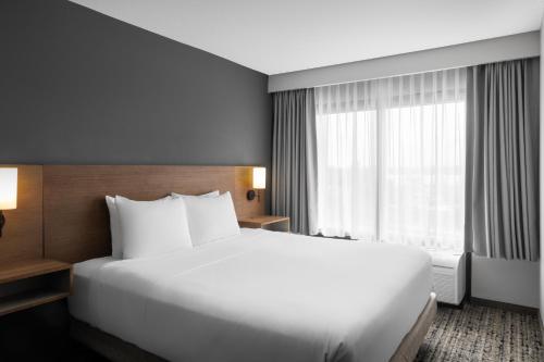 Habitación con cama extragrande, sofá cama y vistas al río del hotel Hyatt Place San Antonio Riverwalk Hotel