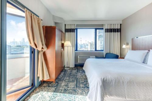 Habitación con cama extragrande, balcón y vistas a la ciudad del hotel Vista LIC Hotel, Premier Collection by Best Western