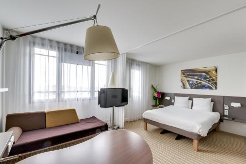 Suite Superior con cama doble, cama individual y sofá cama del hotel Novotel Suites Paris Montreuil Vincennes. Foto 13