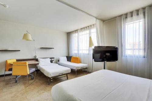 Suite Superior con cama doble, cama individual y sofá cama del hotel Novotel Suites Paris Montreuil Vincennes. Foto 4