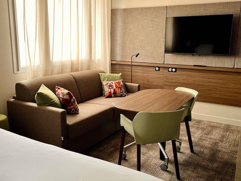 Suite superior con dormitorio, 1 cama doble y 2 sofá - camas individuales del hotel Novotel Suites Clermont Ferrand Polydome. Foto 21