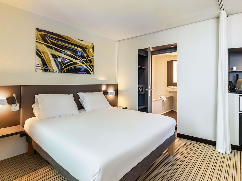 Suite de categoría superior con una cama doble, una cama individual y sofá cama individual del hotel Novotel Suites Gare Lille Europe