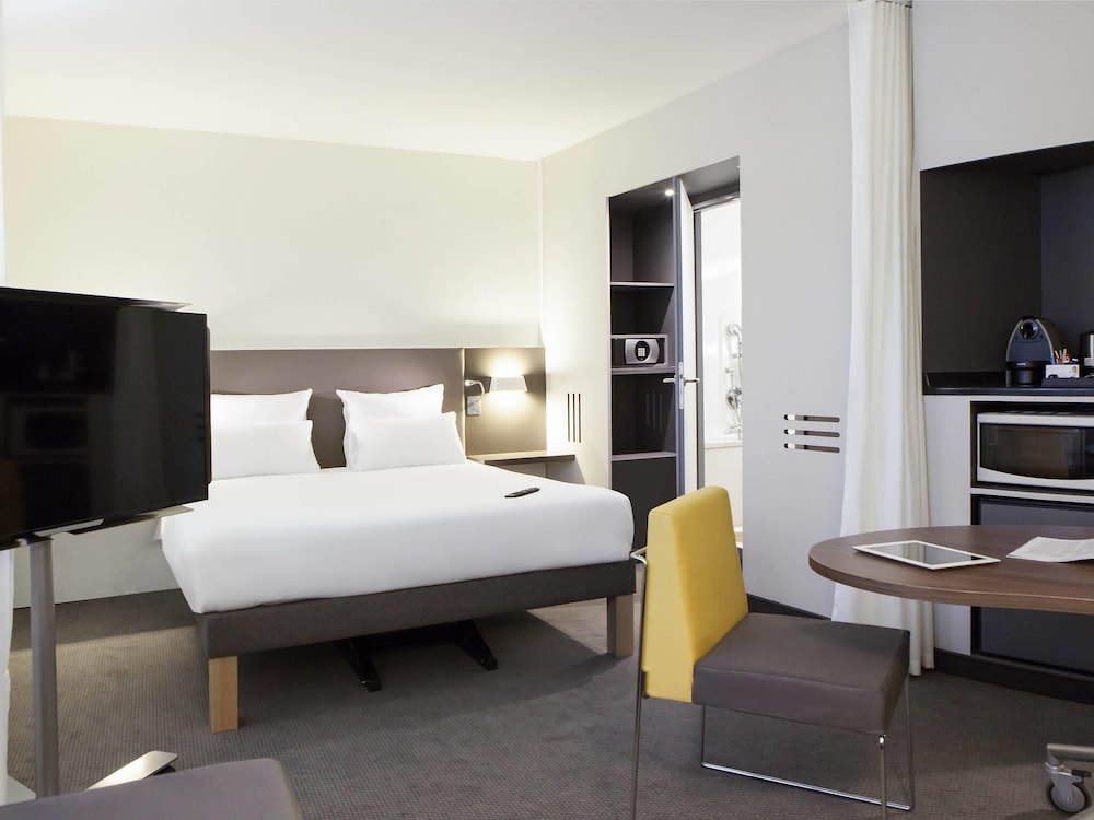 Suite Executive con una cama doble, una cama individual y un sofá cama individual del hotel Novotel Suites Gare Lille Europe