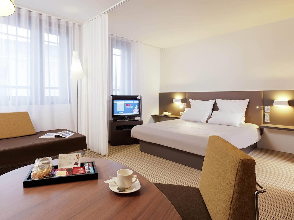 Suite Executive con una cama doble, una cama individual y un sofá cama individual del hotel Novotel Suites Gare Lille Europe. Foto 4