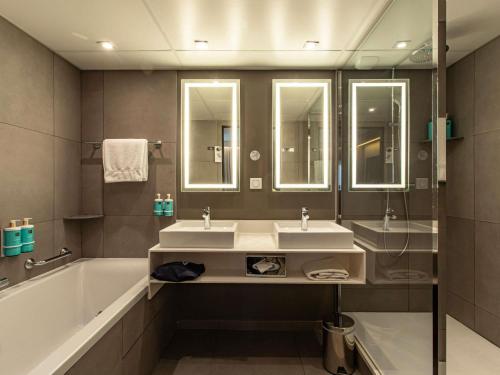 Suite con cama extragrande y sofá del hotel Novotel Paris 14 Porte d'Orléans. Foto 2