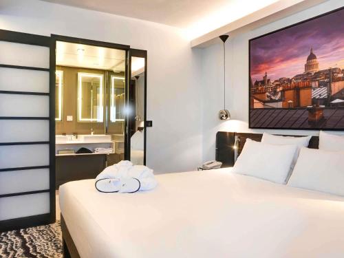 Suite con cama extragrande y sofá del hotel Novotel Paris 14 Porte d'Orléans. Foto 5