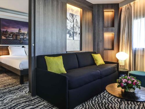 Suite con cama extragrande y sofá del hotel Novotel Paris 14 Porte d'Orléans. Foto 2
