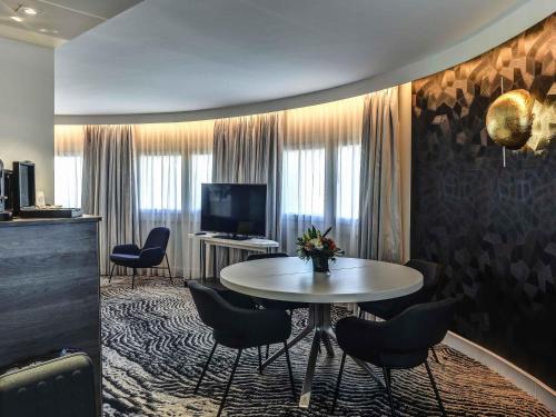 Suite con cama extragrande y sofá del hotel Novotel Paris 14 Porte d'Orléans. Foto 4